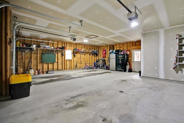 garage with white refrigerator and a garage door opener