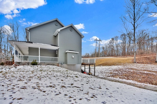 snow covered property featuring covered porch