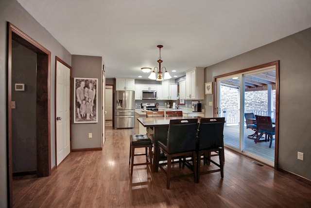 dining room with hardwood / wood-style floors and a notable chandelier