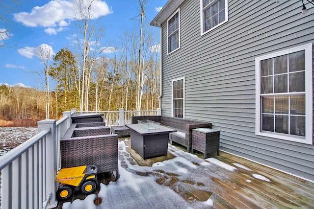 snow covered deck with an outdoor living space with a fire pit