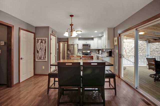 dining space with a chandelier and dark hardwood / wood-style flooring