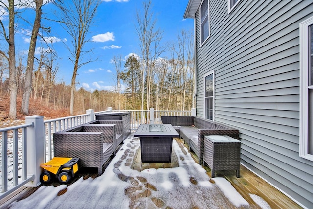 snow covered deck featuring an outdoor living space with a fire pit