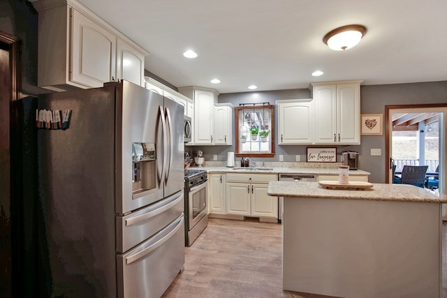 kitchen featuring appliances with stainless steel finishes, sink, a wealth of natural light, and light hardwood / wood-style floors