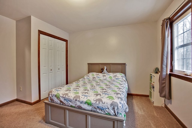 bedroom featuring a closet, multiple windows, and light colored carpet