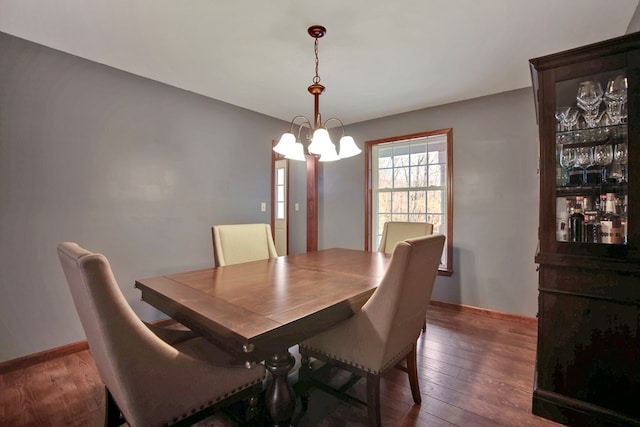 dining area featuring an inviting chandelier and dark hardwood / wood-style flooring