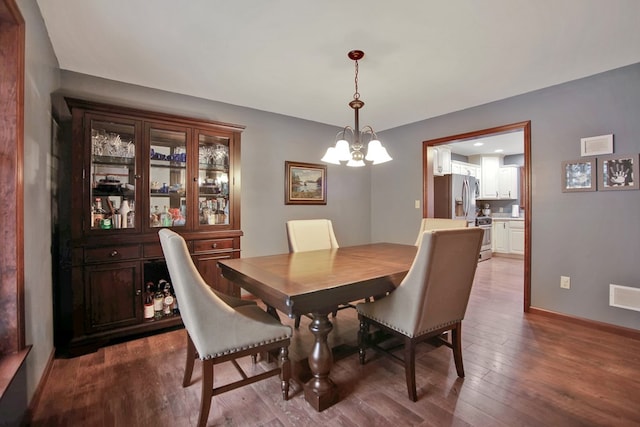 dining area with hardwood / wood-style flooring and a chandelier