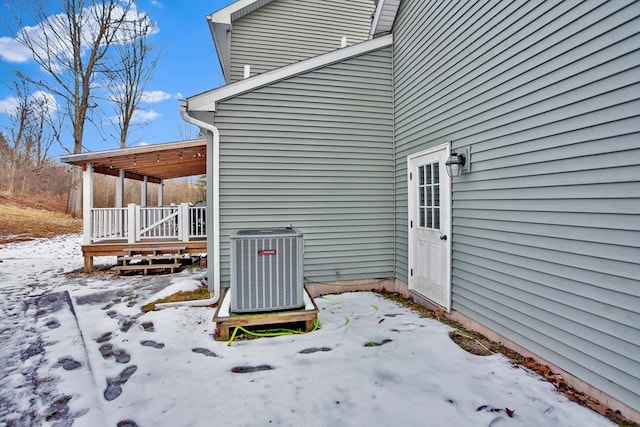 snow covered patio featuring central AC unit