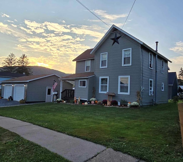 view of front of home featuring a lawn, an outdoor structure, and a garage