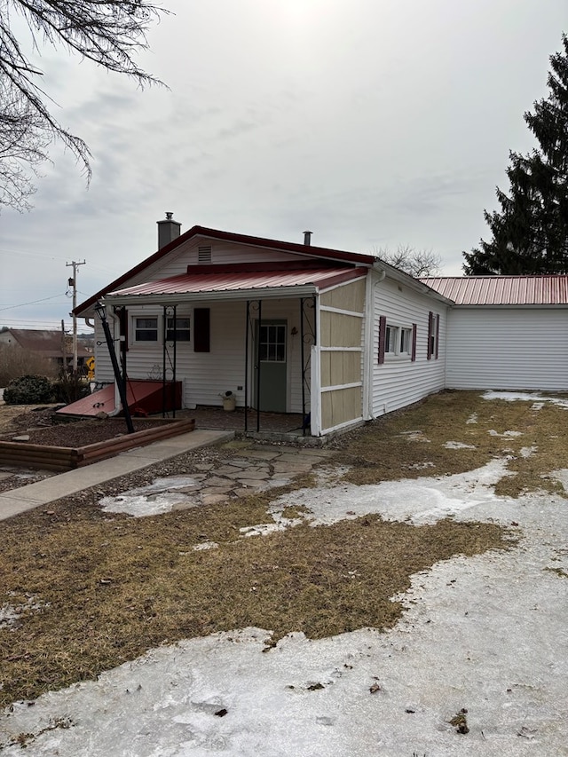 view of front of property with metal roof and a chimney