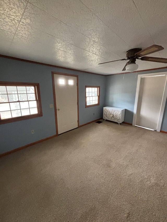 carpeted foyer entrance featuring baseboards, visible vents, and a textured ceiling