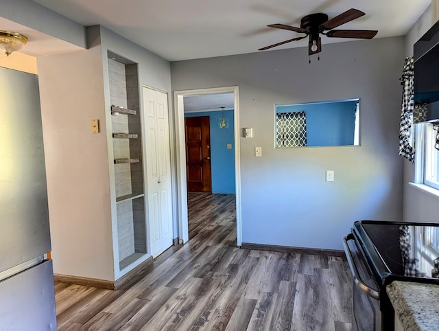 kitchen with wood-type flooring, black range with electric stovetop, stainless steel refrigerator, and ceiling fan