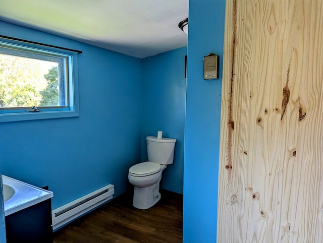 bathroom featuring hardwood / wood-style flooring, toilet, vanity, and a baseboard heating unit