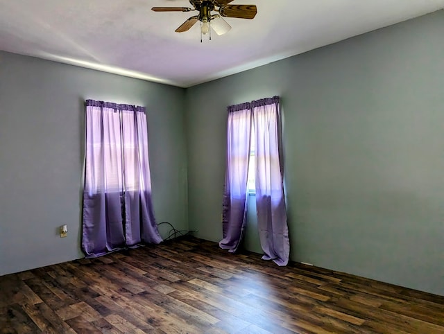 empty room with ceiling fan and dark wood-type flooring