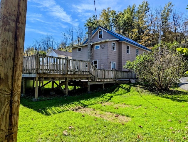 rear view of property with a lawn and a deck