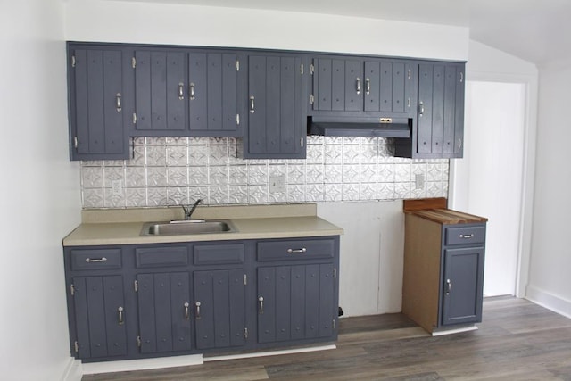 kitchen with tasteful backsplash, dark wood-type flooring, and sink