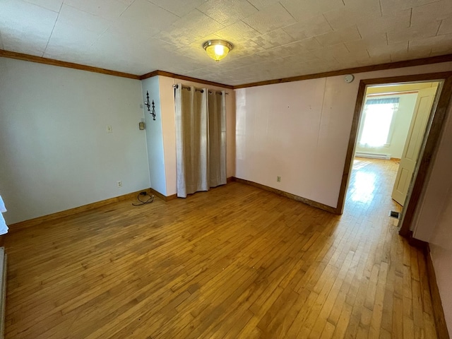 unfurnished room with ornamental molding, a baseboard heating unit, and light hardwood / wood-style floors