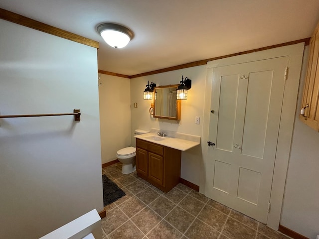 bathroom with crown molding, vanity, and toilet