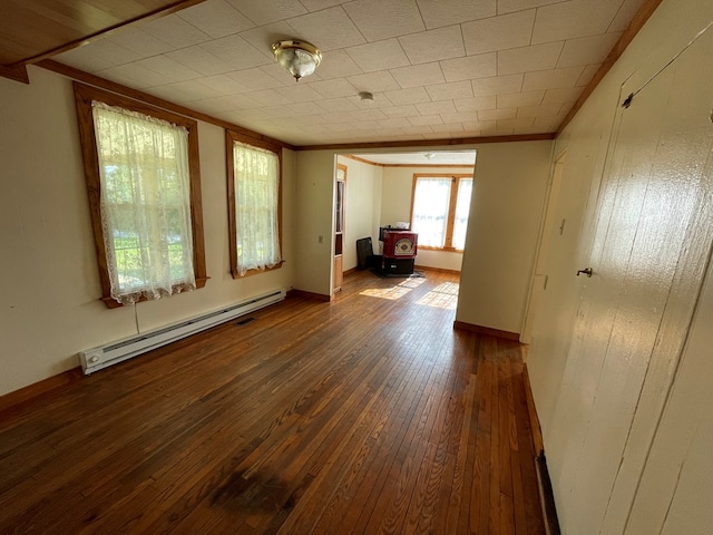 spare room featuring ornamental molding, dark wood-type flooring, and a baseboard heating unit