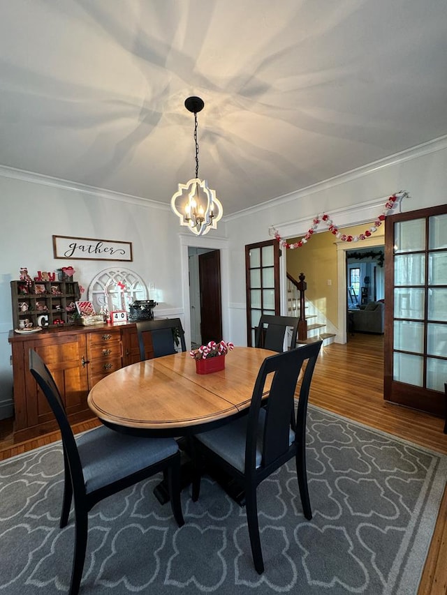 dining area with hardwood / wood-style floors, crown molding, and french doors