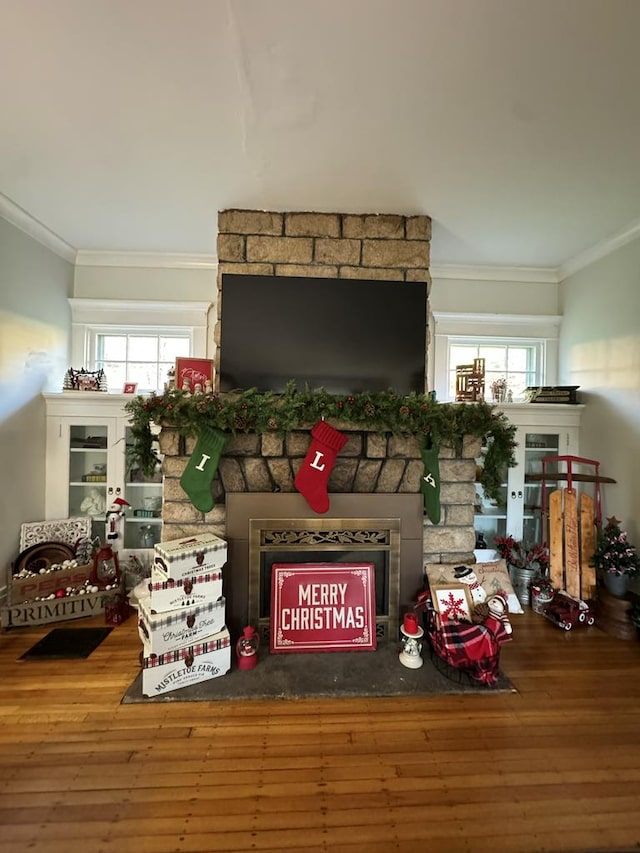 living area with plenty of natural light, crown molding, and wood finished floors