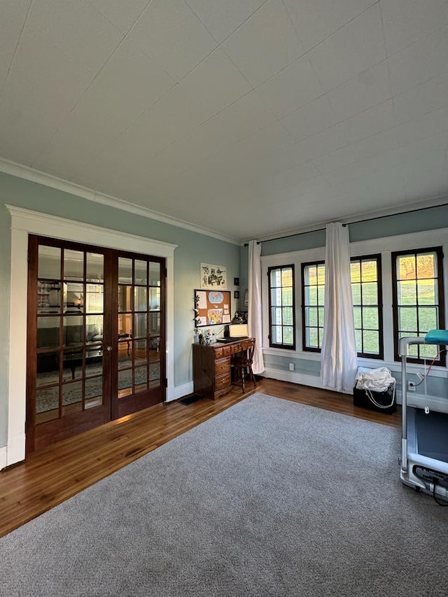 interior space with crown molding, baseboards, wood finished floors, and french doors