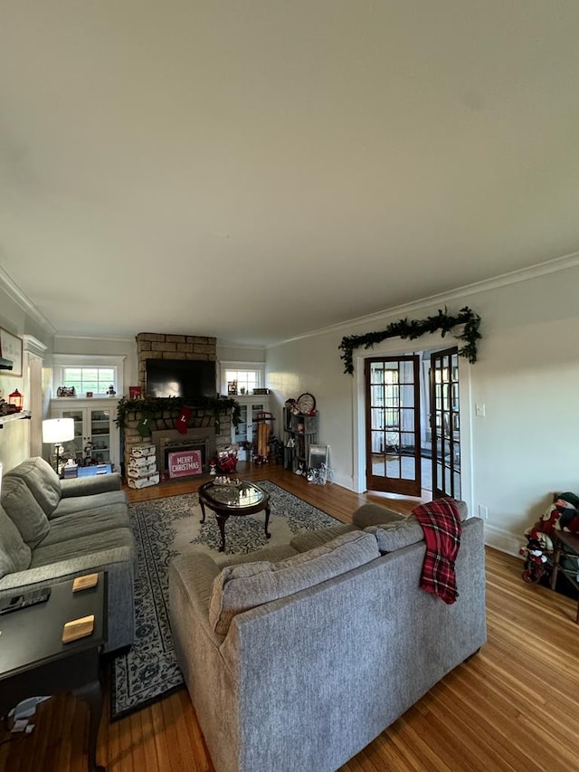 living room featuring a healthy amount of sunlight, crown molding, and wood finished floors