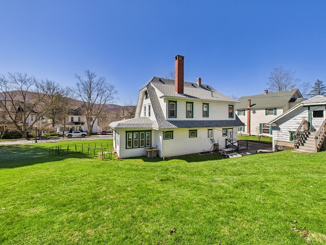 1010 W Main St, Smethport, PA 16749 - rear view of house with fence, a chimney, a yard, and roof with shingles