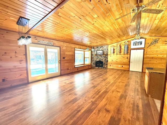 unfurnished living room with a fireplace, hardwood / wood-style floors, wooden ceiling, and wooden walls