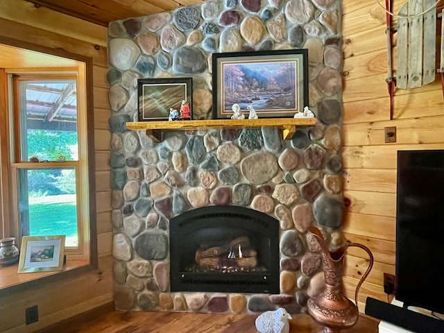 interior details with a fireplace, hardwood / wood-style floors, and wood walls