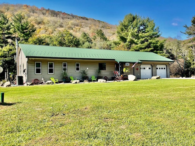 single story home featuring a front yard, a mountain view, a garage, and cooling unit