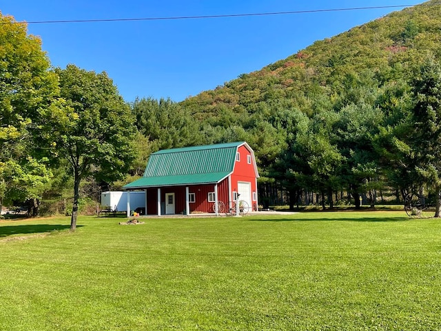 view of outdoor structure with a yard and a mountain view