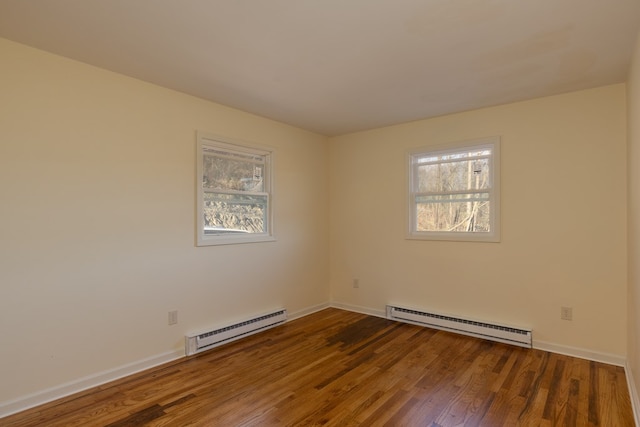 unfurnished room featuring hardwood / wood-style floors and a baseboard heating unit