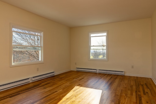 empty room featuring hardwood / wood-style floors and baseboard heating