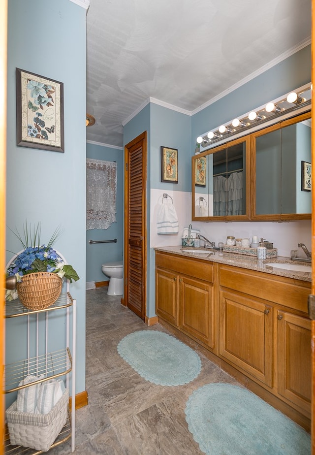 bathroom featuring vanity, toilet, and crown molding