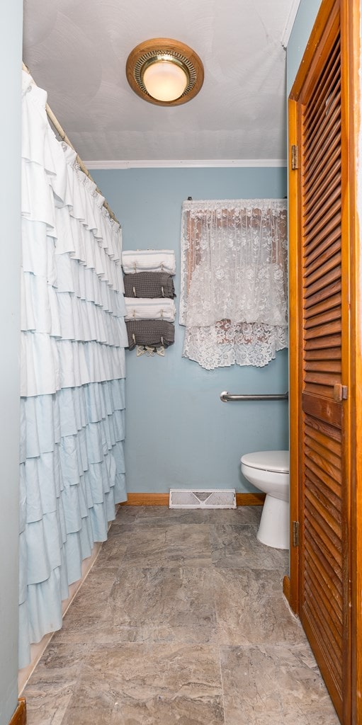 full bath featuring visible vents, stone finish flooring, toilet, a shower with shower curtain, and baseboards