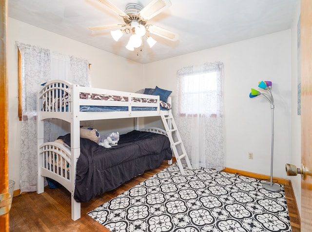 bedroom with wood finished floors, baseboards, and a ceiling fan