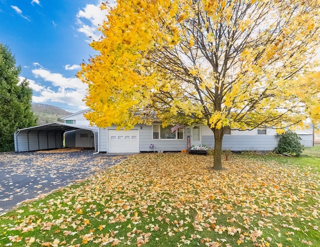 view of property hidden behind natural elements with a mountain view, a garage, and a carport