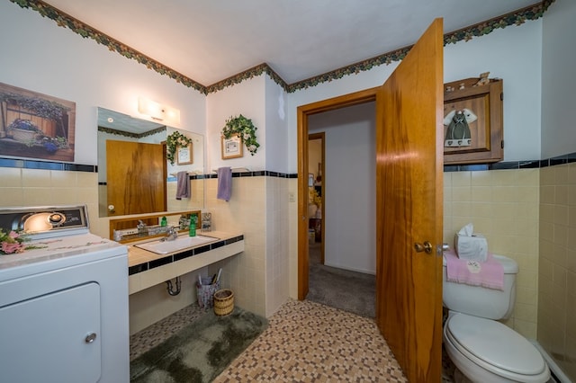 517 Mohawk St, Sayre, PA 18640 - bathroom featuring washer / dryer, tile walls, a sink, toilet, and wainscoting