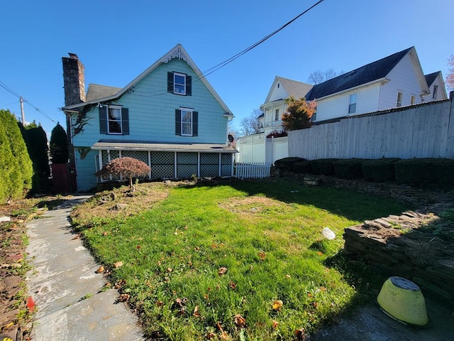 back of house featuring a lawn