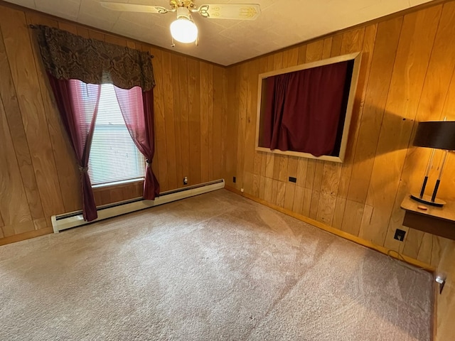 401 Center St, Ulysses, PA 16948 - carpeted empty room with a baseboard radiator, wood walls, and a ceiling fan