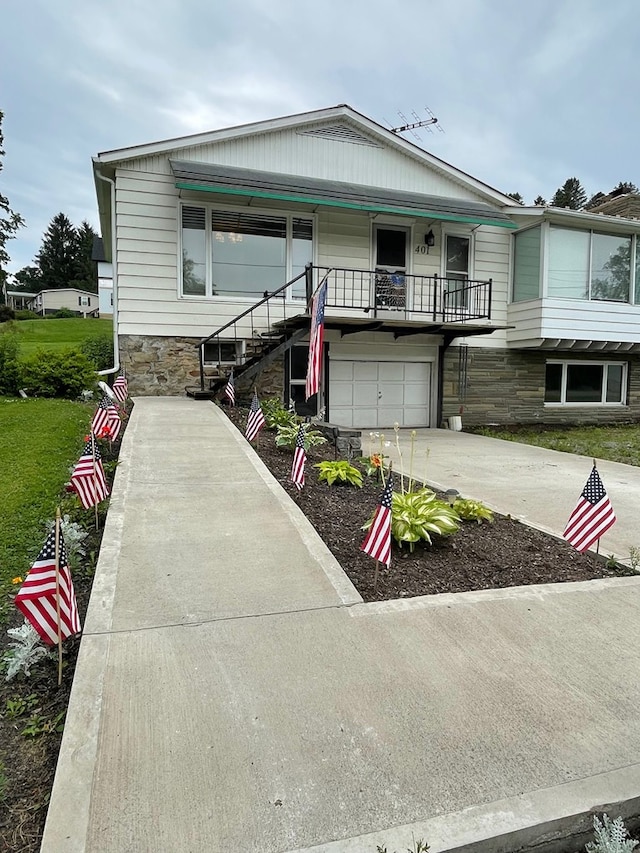 401 Center St, Ulysses, PA 16948 - view of front of home featuring a garage, concrete driveway, stone siding, and stairs