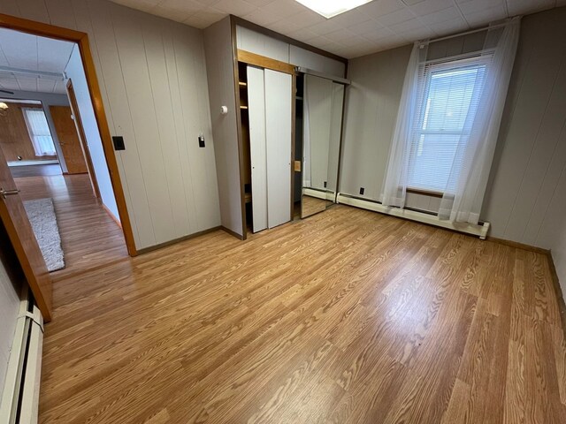 401 Center St, Ulysses, PA 16948 - unfurnished bedroom featuring light wood-style floors, baseboard heating, two closets, and a paneled ceiling