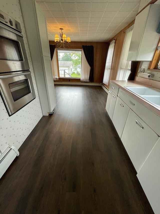 401 Center St, Ulysses, PA 16948 - kitchen featuring a chandelier, double oven, white cabinetry, baseboard heating, and light countertops