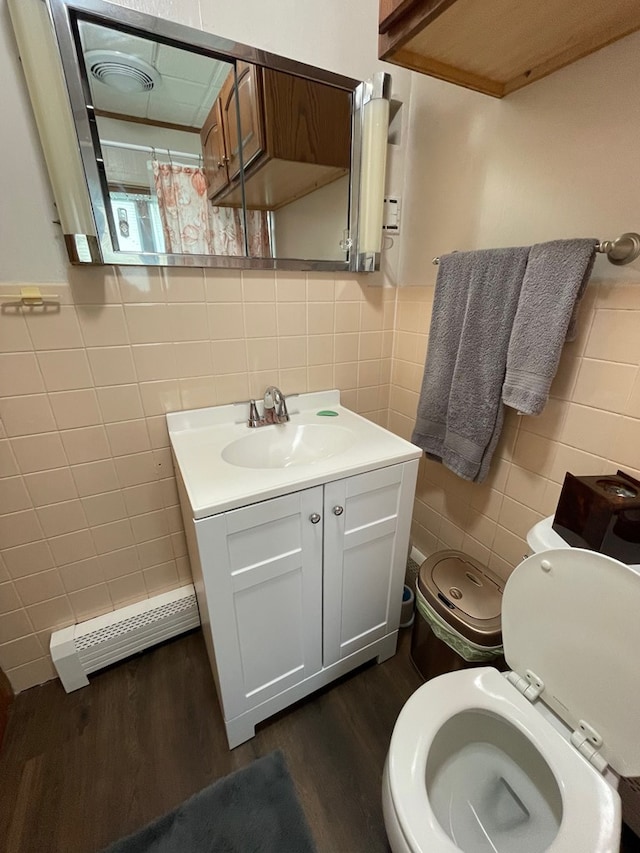 401 Center St, Ulysses, PA 16948 - full bathroom featuring tile walls, wood finished floors, vanity, a shower with curtain, and a baseboard radiator