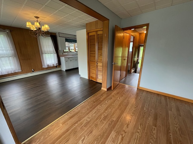 401 Center St, Ulysses, PA 16948 - unfurnished living room with a chandelier, wood finished floors, and a baseboard heating unit