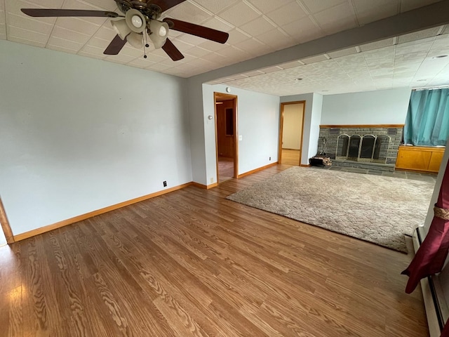 401 Center St, Ulysses, PA 16948 - unfurnished living room featuring a fireplace with raised hearth, wood finished floors, and a ceiling fan