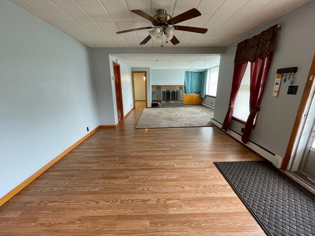 401 Center St, Ulysses, PA 16948 - unfurnished living room with a fireplace, light wood-type flooring, ceiling fan, and baseboard heating