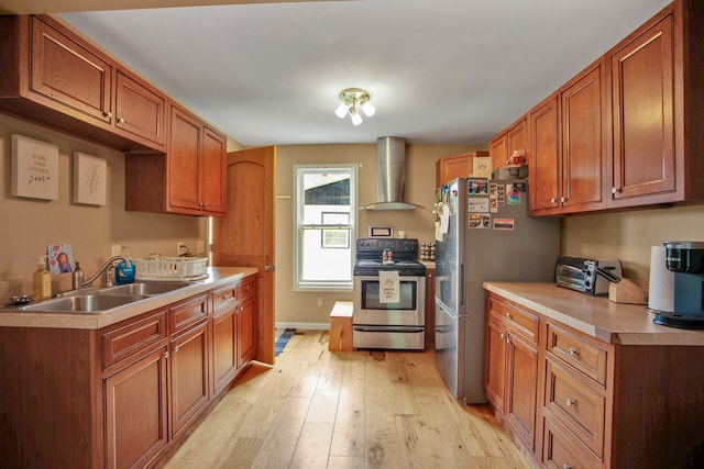 40 Wetmore St, Wellsboro, PA 16901 - kitchen with stainless steel appliances, wall chimney range hood, light wood finished floors, light countertops, and brown cabinetry