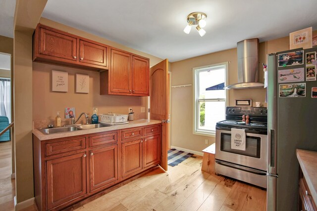 40 Wetmore St, Wellsboro, PA 16901 - kitchen with stainless steel appliances, wall chimney exhaust hood, light wood-style flooring, and brown cabinets