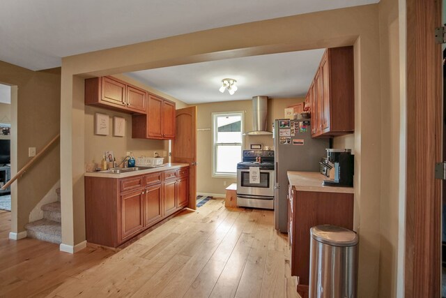 40 Wetmore St, Wellsboro, PA 16901 - kitchen with appliances with stainless steel finishes, wall chimney range hood, light countertops, and light wood-style floors